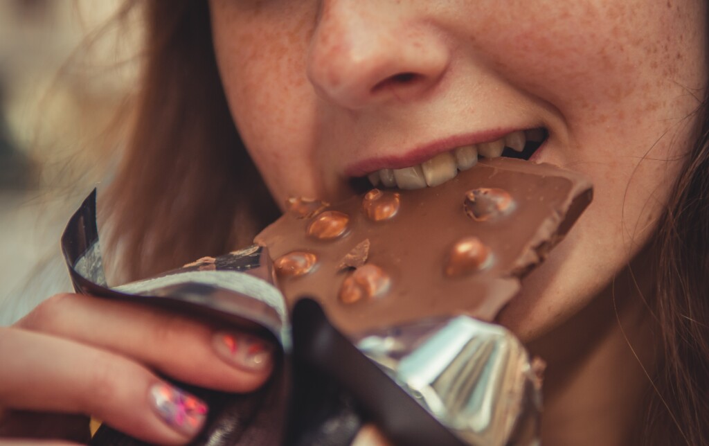Nainen syö suklaalevyä
