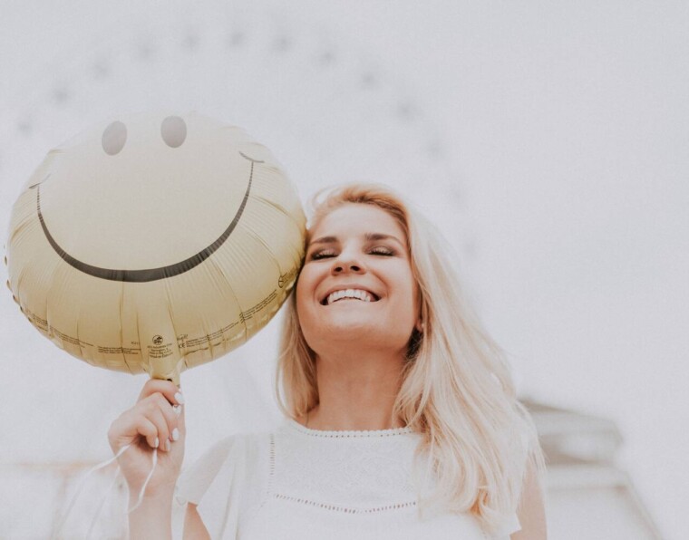 Motivoiva kuva naisesta jolla smile-ilmapallo ja leveä hymy