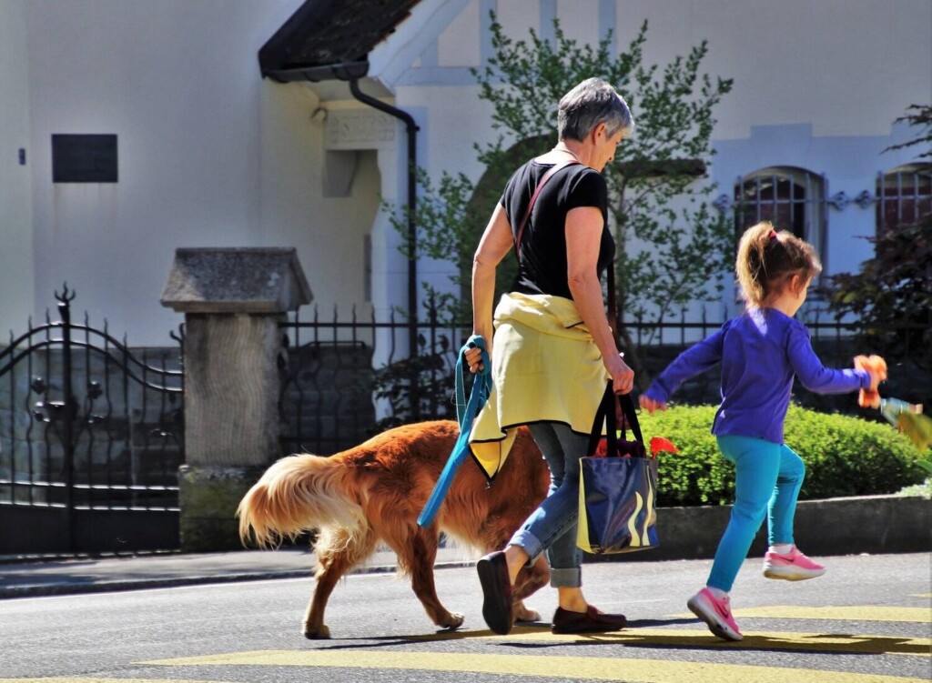 nainen ja lapsi kävelyttävät koiraa